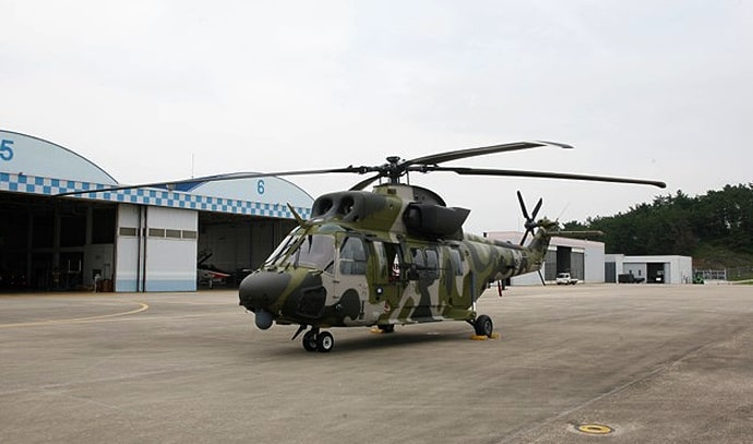 위장무늬의 한국 육군 헬리콥터가 격납고 앞 주기장에 주차되어 있는 모습