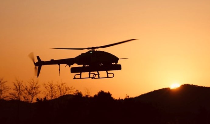 노을진 하늘을 배경으로 실루엣으로 보이는 무인헬기가 비행 중인 모습