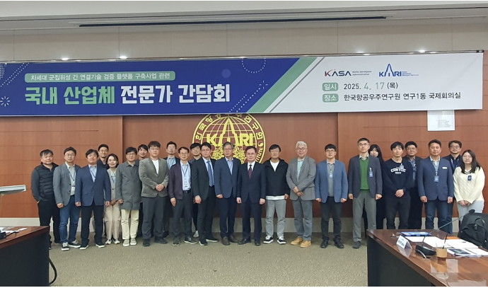 '차세대 군집위성 간 연계기술 검증 플랫폼 구축사업 관련 국내 산업체 전문가 간담회' 현수막 아래, 한국항공우주연구원 국제회의실에서 산업체 및 연구진 관계자들이 단체 사진을 촬영한 장면. 2025년 4월 17일 행사로, 간담회가 공식적으로 진행되었음을 보여주는 사진이다.