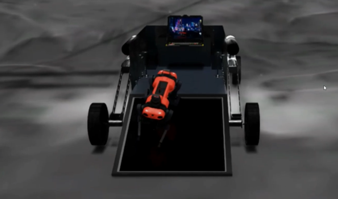 탐사 차량 위에 장착된 검은색 발판 위로 4족 보행 로봇이 올라오고 있는 모습. 차량 안에는 제어 장치와 디스플레이가 장착되어 있으며, 로봇은 정면에서 관측되는 상태로, 임무 종료 후 복귀 중인 것으로 보인다.