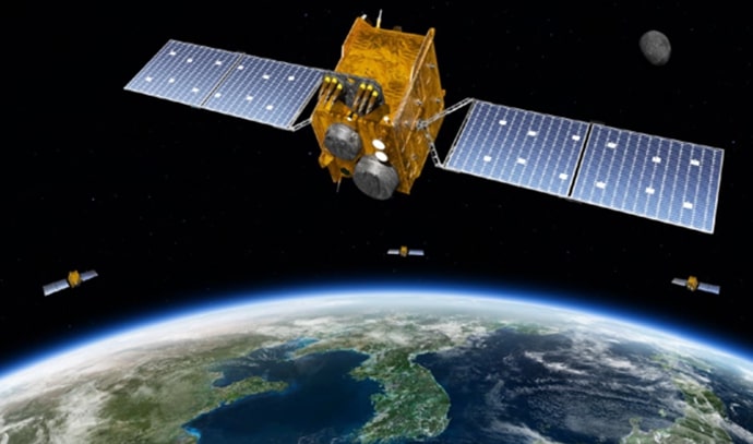 지구 궤도 위를 도는 인공위성을 묘사한 3D 그래픽 이미지. 화면 중앙에는 대형 태양광 패널이 양옆으로 펼쳐진 금색 위성이 있고, 그 아래에는 푸른빛의 한반도를 포함한 동북아시아 지역이 보인다. 주변에는 여러 개의 소형 위성들이 함께 떠 있으며, 멀리에는 달처럼 보이는 천체도 배경에 위치해 있다. 이 이미지는 인공위성을 통한 지구 관측 또는 위성 항법 시스템(GNSS)과 같은 우주 기반 기술의 활용을 시각적으로 표현한 것이다.